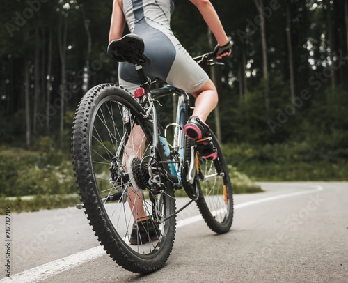 Young Woman Riding on Mountain Bicycle near Forest