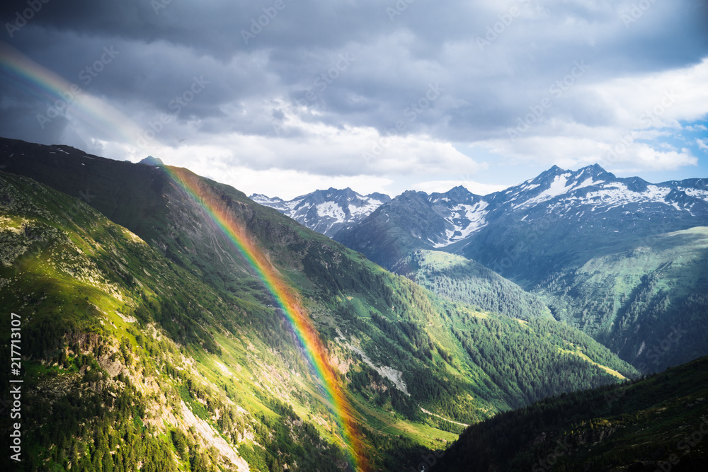 Naklejka premium Rainbow in the mountain valley after rain. Grimselpass, Switzerland