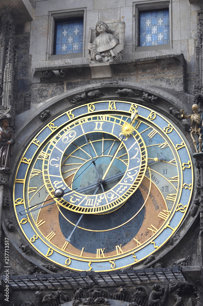 Details of Prague's Astronomical Clock. A statue is above the clock, between two blue windows with white stars.