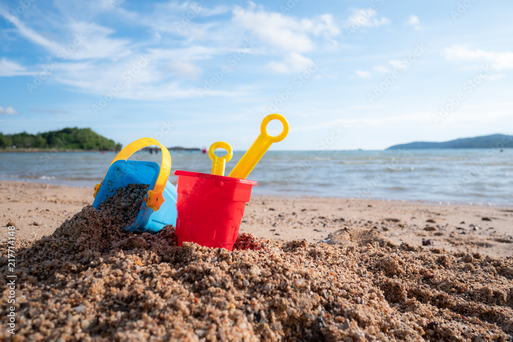 Toy against scenic of summer sand beach and cloudy blue sky Toy against scenic of summer sand beach and cloudy blue sky