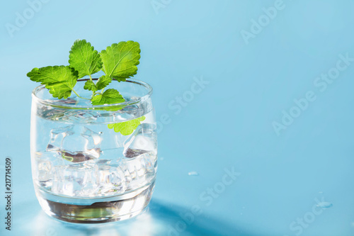 Glass of water with mint on pastel blue. One shot for time. Close up. Water balance for healthy.