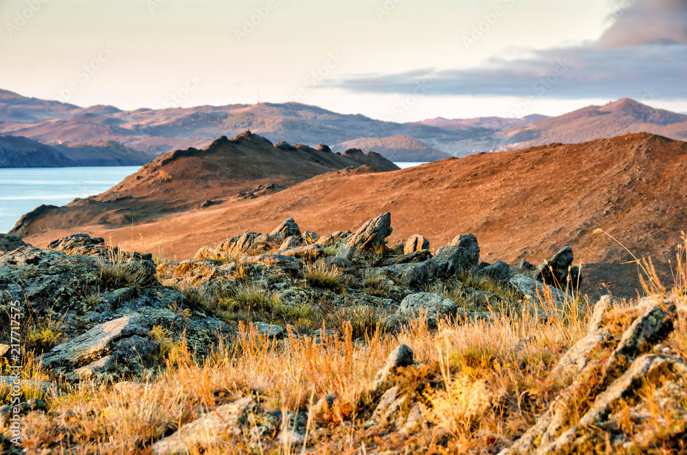 Fototapeta premium Landscape with rock and lake on sunset background