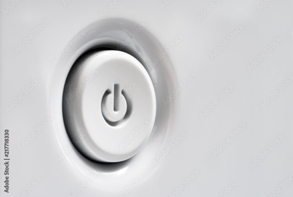 Power button in white. Side view of the start button. Selective focus.