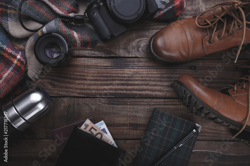 Traveler's photographer's accessories camera lense boots thermos purse with money plaid and notepad on old barn wood background