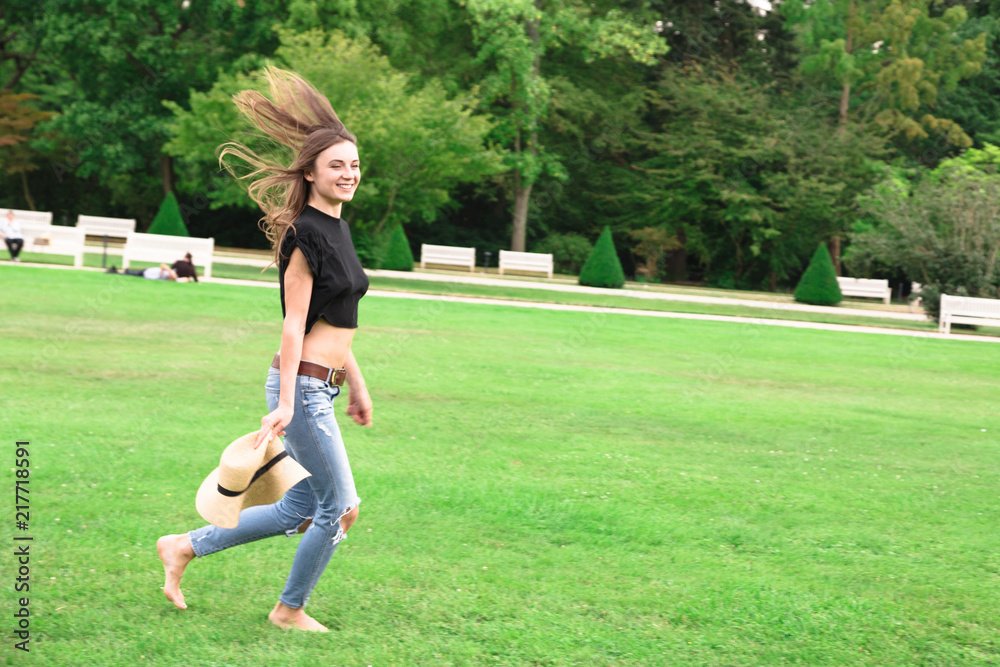 Young beautiful fit woman running in green park