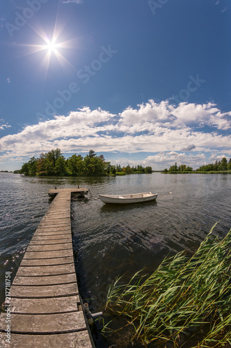 Fototapeta Naklejka Na Ścianę i Meble -  Boat and a jetty on a sunny summer day