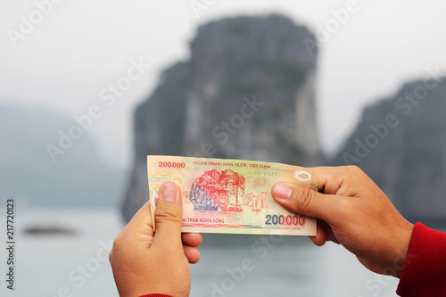 A Vietnamese note of two hundred thousand dong shot against the limestone in Ha Long Bay that is printed in the note photo