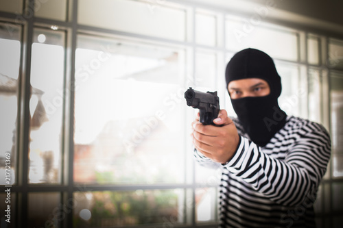 Robber holding a gun and pointing it at the victim.The concept of robbery and crime.