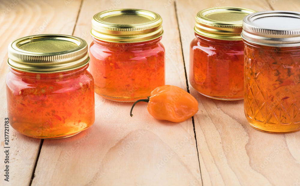 Φωτογραφία Glass jars with habanero jelly and one with jalapeno jelly.