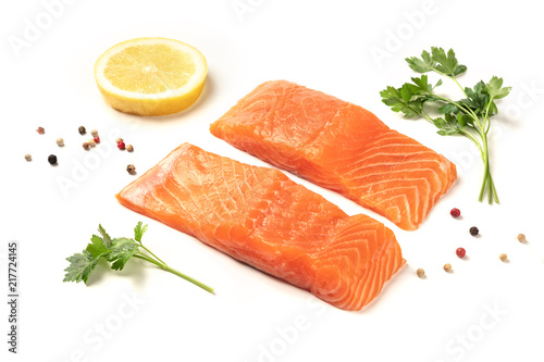 Slices of salmon with lemon, parsley, and pepper, on a white background with copy space