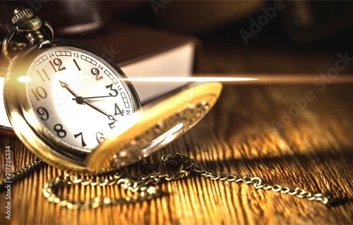 Vintage pocket watch on wooden surface against