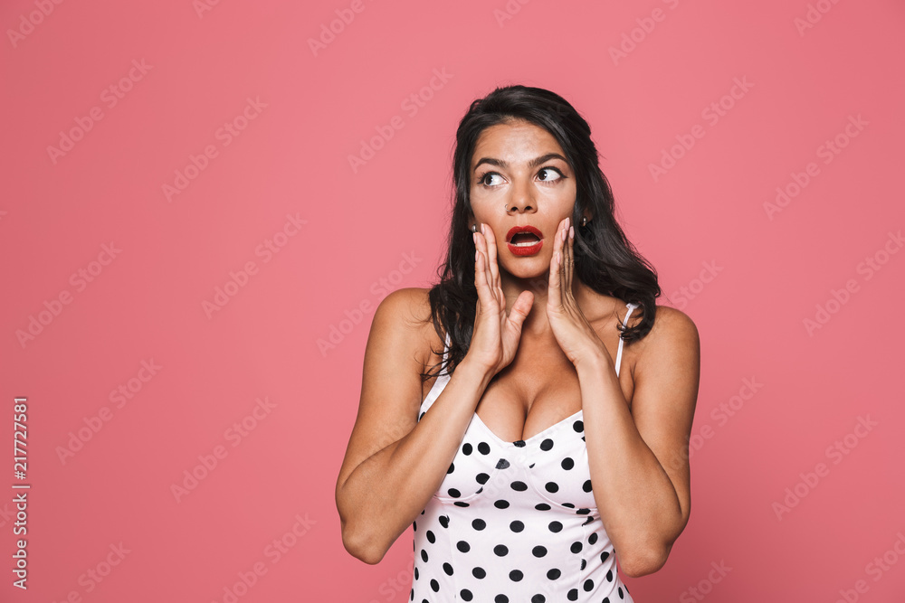 Suprised woman in swimwear posing isolated over pink wall background looking aside with mouth opened. Suprised woman in swimwear posing isolated over pink wall background looking aside with mouth opened.