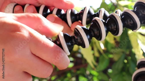 Hands using a gorillapod. Handling a portable and flexible mini tripod SLOW MOTION photo