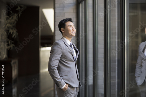 Wallpaper Mural Confident businessman looking through window Torontodigital.ca