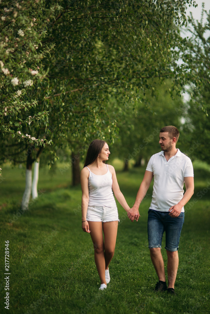 Dating in park. Love couple walking together on grass near the lake. Romance and love Dating in park. Love couple walking together on grass near the lake. Romance and love
