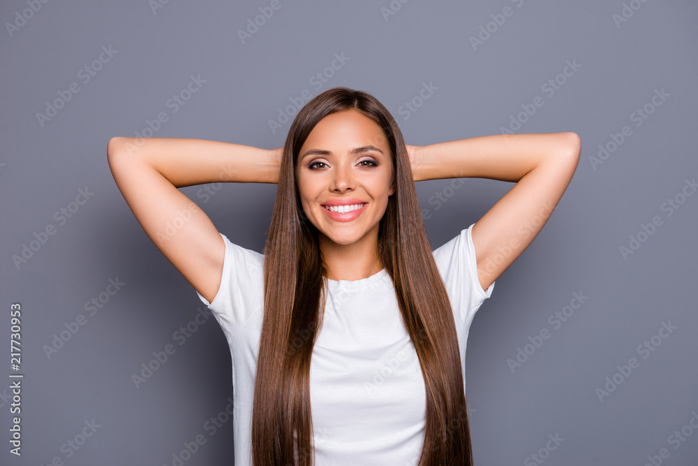 Portrait of brown-haired gorgeous attractive nice smiling cheerful confident young lady holding hands back head, over grey background, isolated Portrait of brown-haired gorgeous attractive nice smiling cheerful confident young lady holding hands back head, over grey background, isolated