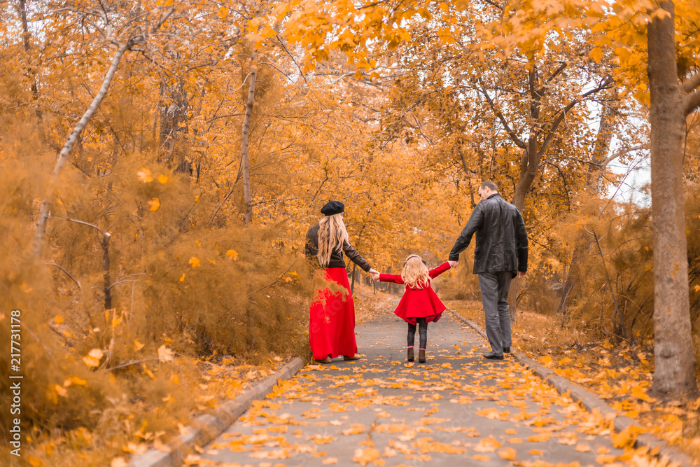father, mother and little daughter walk in the autumn park father, mother and little daughter walk in the autumn park