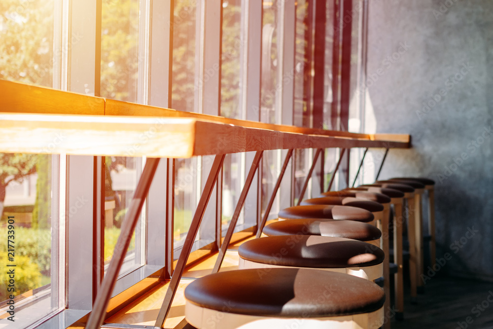 interior cafe. Bar stools stand in row near large window interior cafe. Bar stools stand in row near large window