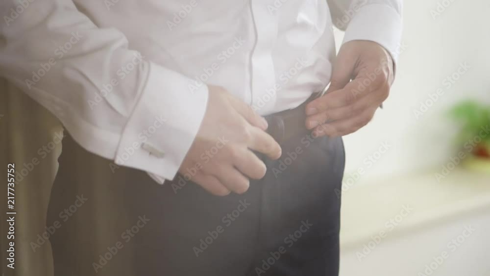 Man Fastens Black Belt on Suit with White Shirt Man Fastens Black Belt on Suit with White Shirt