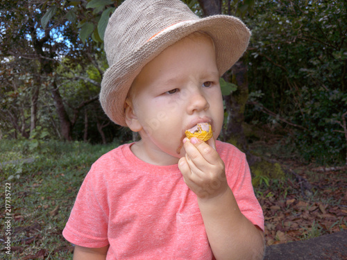 Cute boy in the hat eating ice cream in the park