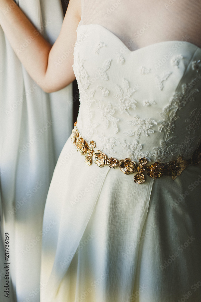 Detail of a white and elegant wedding dress. Detail of a white and elegant wedding dress.