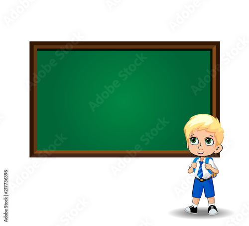 Cute little blonde school boy with big green eyes near blackboard on white background.