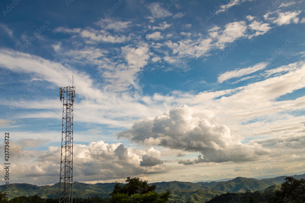 Telephone towers are located on high mountain, to transmit signals covering the area. with white clouds and blue sky background.