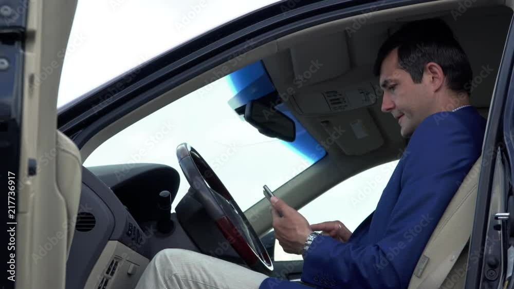 Successful businessman is having a business conversation in the car by phone Successful businessman is having a business conversation in the car by phone