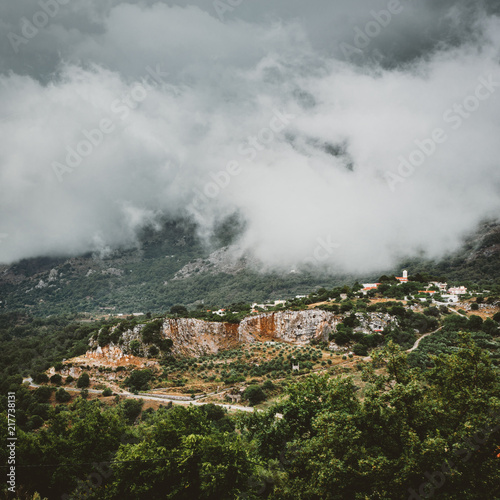 View on mountain with low hanging clouds and green trees. South Crete neat Rethymno, Greece