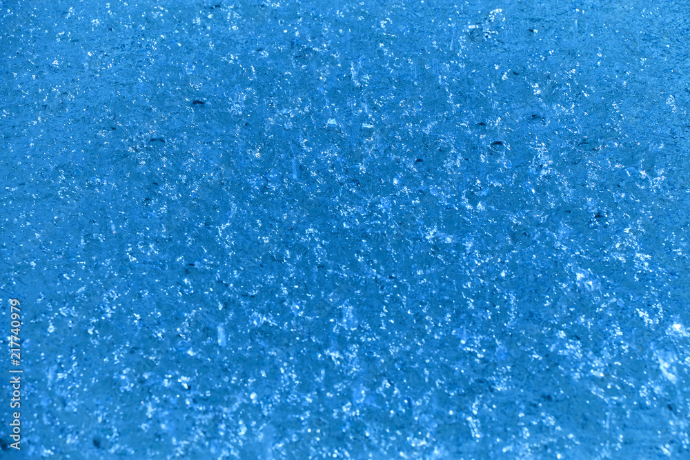 Closeup of beautiful dynamic water surface with falling droplets in blue color.