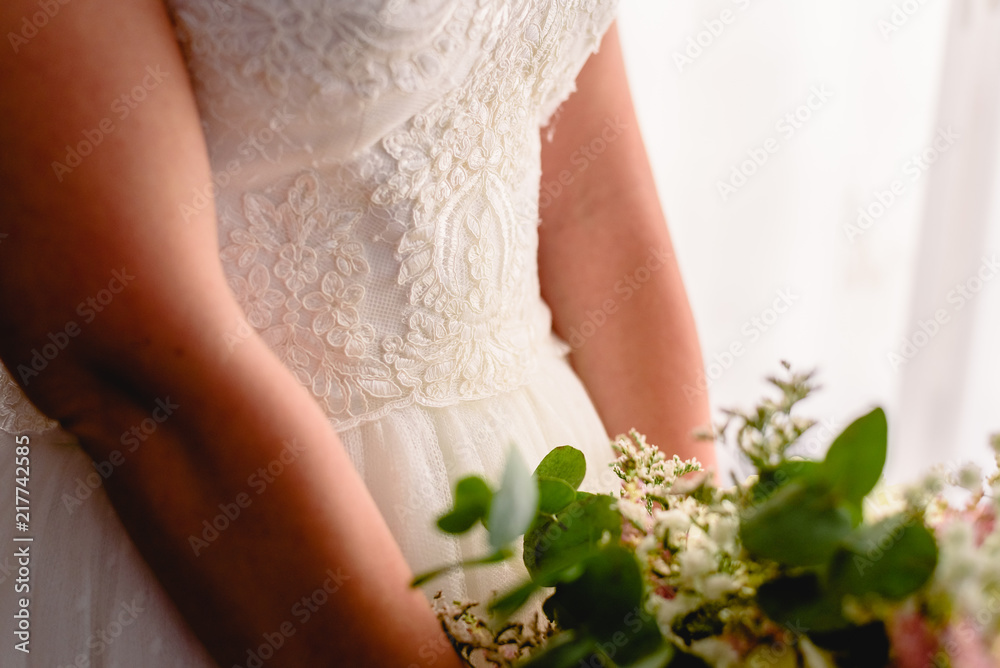 Bride holding her wedding bouquet with white dress.