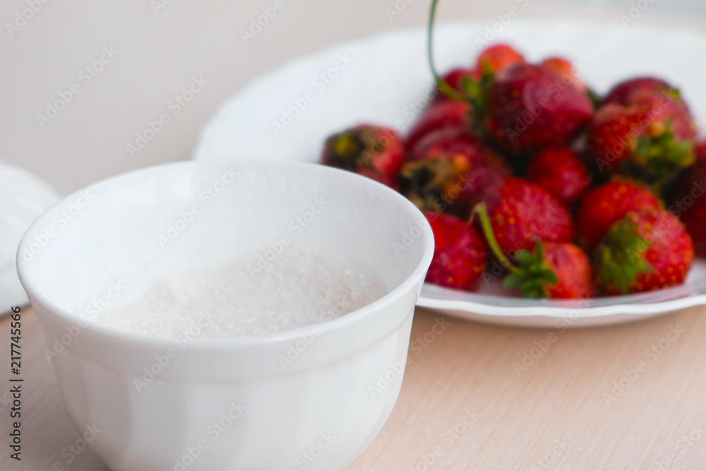 Juicy appetizing tasty strawberry on a white plate with sugar bowl. Juicy appetizing tasty strawberry on a white plate with sugar bowl.