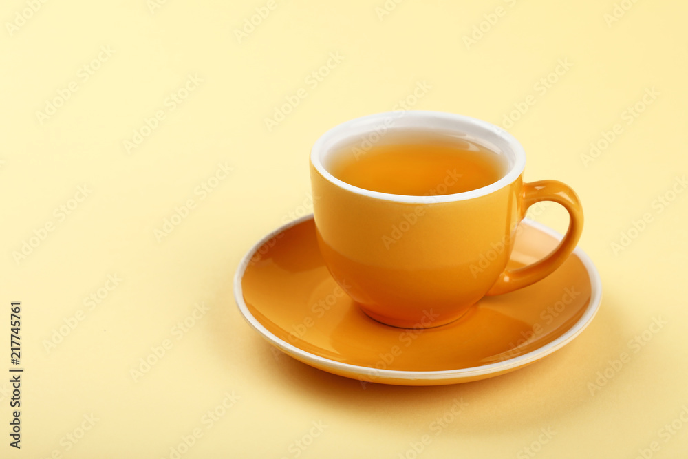 Yellow cup of green oolong tea on saucer Yellow cup of green oolong tea on saucer
