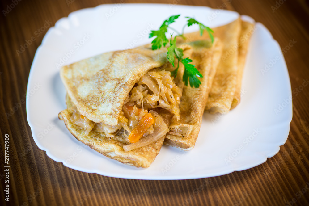 thin fried pancakes stuffed with stewed cabbage in a plate thin fried pancakes stuffed with stewed cabbage in a plate