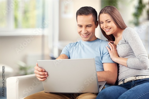 Young business couple using laptop at home,
