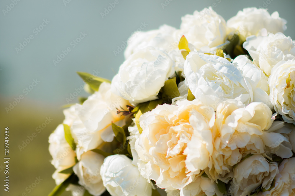 Obraz premium Beautiful wedding floral composition of white and cream peony on the nature background. Wedding decor for outdoor ceremony