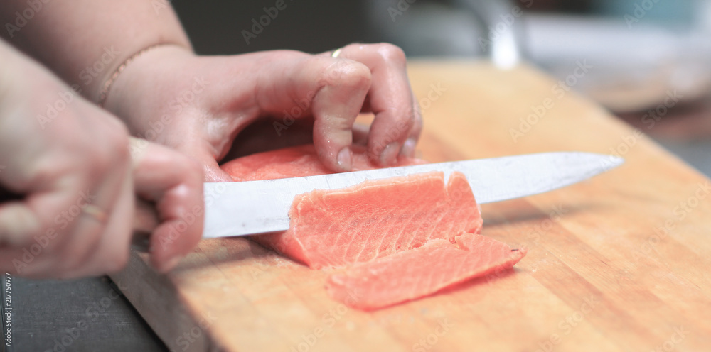 close up. chef slicing fish for sushi