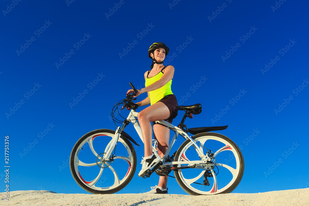 Woman on a bicycle against the blue sky