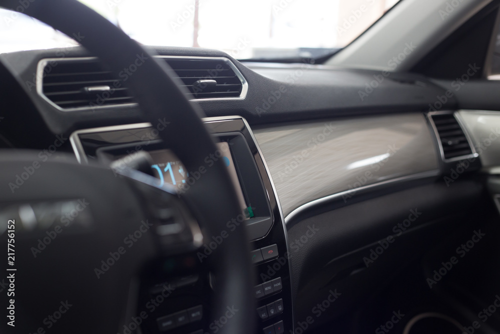 Car interior. Modern car illuminated dashboard. Luxurious car instrument cluster. Close up shot of car instrument panel. Modern car interior dashboard and steering wheel