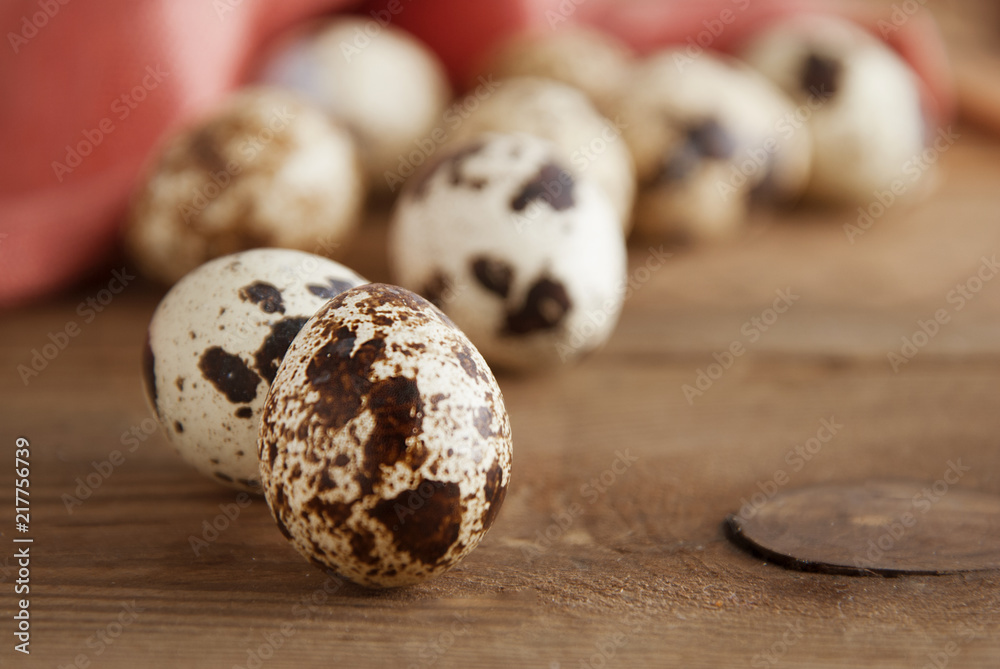Obraz premium Quail eggs on a wooden table. Close up fresh quail eggs, rustic style and napkin. Copy space.