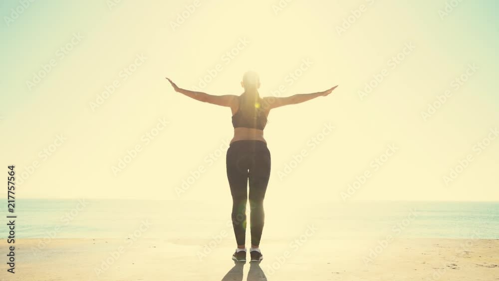 Beautiful sportive girl training at sunrise over seaside. Woman doing yoga against the sea and sun. Beautiful sportive girl training at sunrise over seaside. Woman doing yoga against the sea and sun.
