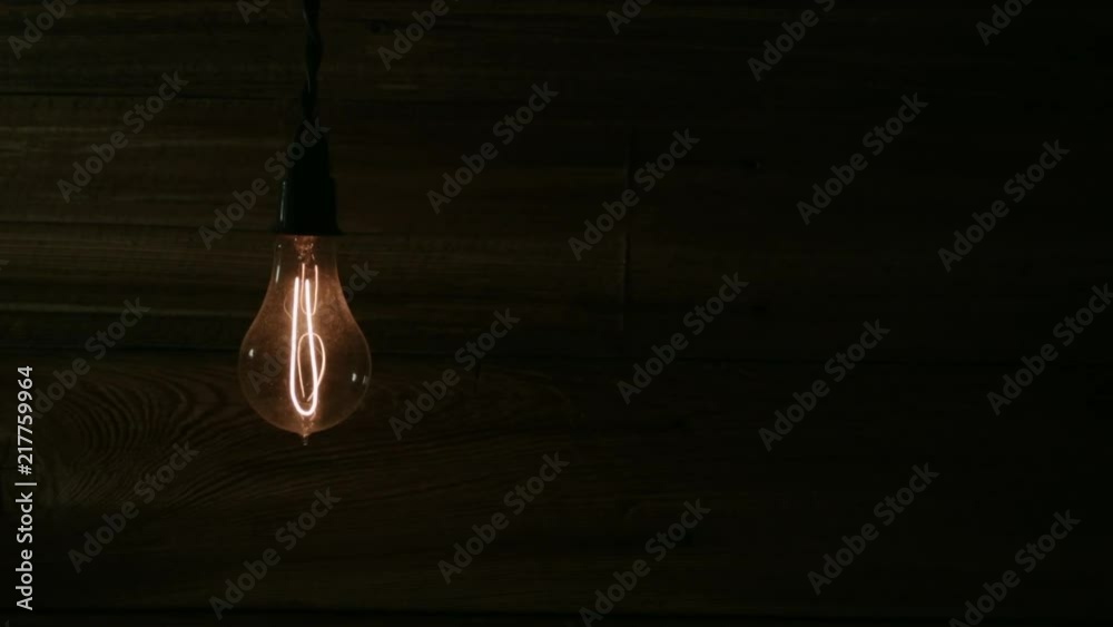 EDISON BULB SLOWLY ILLUMINATES, WITH NEGATIVE SPACE