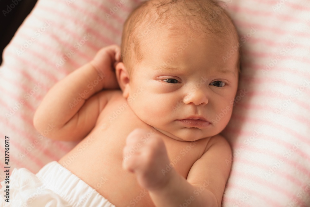 Newborn baby relaxing on baby bed Newborn baby relaxing on baby bed