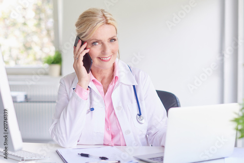 Female doctor consulting with her patient on mobile phone
