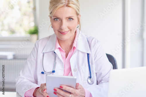 Female doctor using toucpad at the private clinic photo