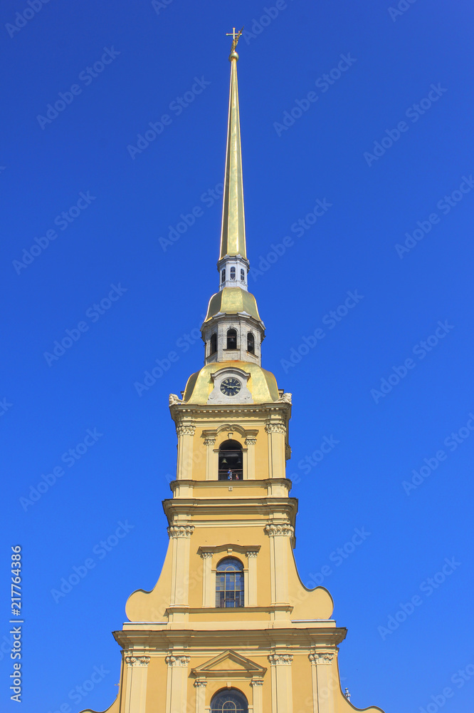 Peter and Paul Cathedral at Peter and Paul Fortress in Saint Petersburg, Russia. Bell Tower of Russian Orthodox Church, Building Architecture Details. Church Tower View on Clear Blue Sky Background. Peter and Paul Cathedral at Peter and Paul Fortress in Saint Petersburg, Russia. Bell Tower of Russian Orthodox Church, Building Architecture Details. Church Tower View on Clear Blue Sky Background.