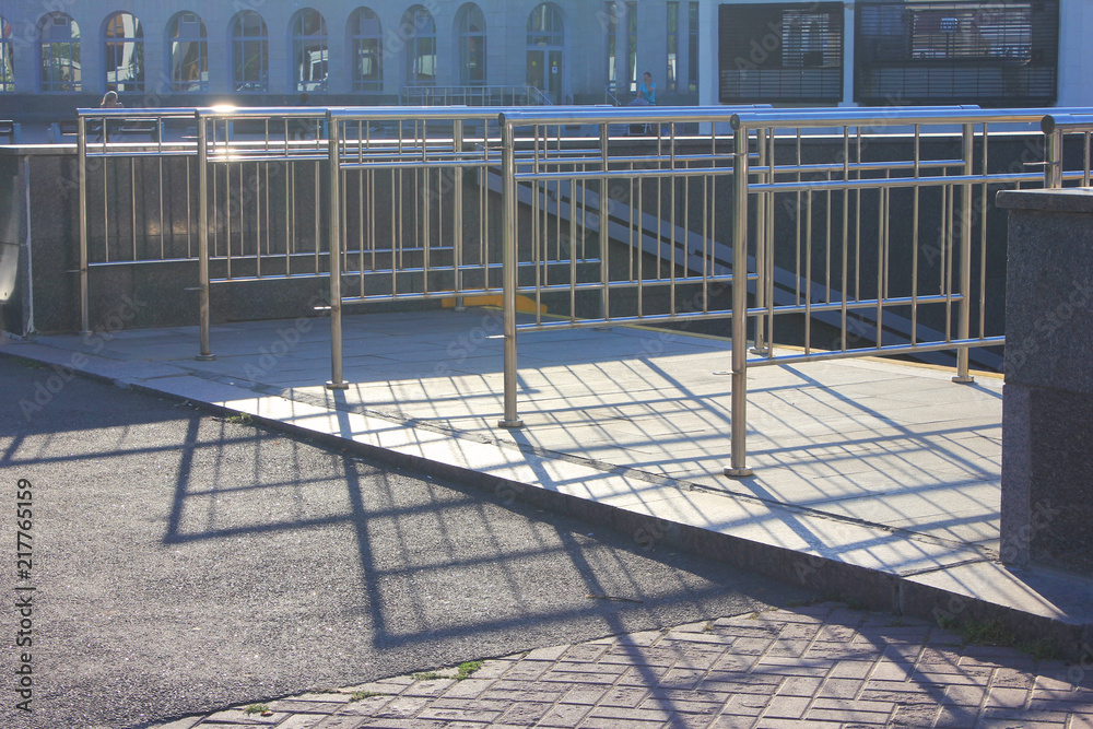 Metal Entrance Security Railing Gate to Sports Stadium, Arena, Concert Venue or Subway Underground Station with Sun Shining on Summer Day. Empty Entry Point with Drop Shadows on a Light Ground.