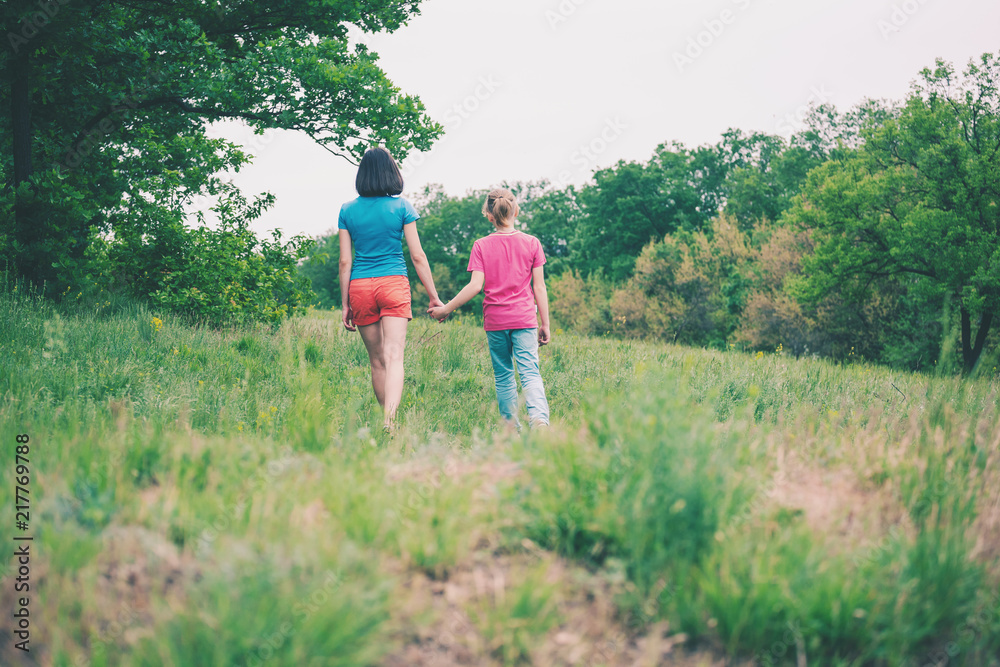 The boy walks with his mother in the meadow. The boy walks with his mother in the meadow.