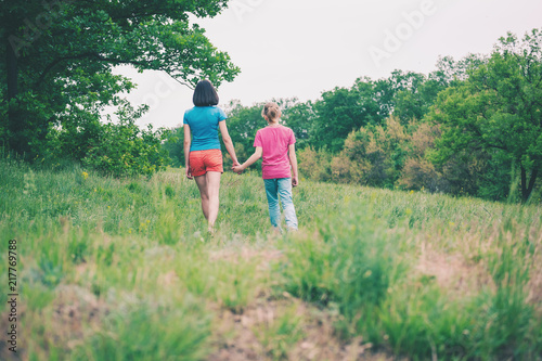 The boy walks with his mother in the meadow. © zhukovvvlad