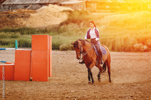 Young horse rider woman jockey on equestrian sport competition. Arena background